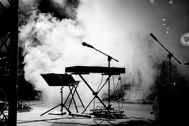 Keyboard en microfoon op een podium met een wolk erachter.